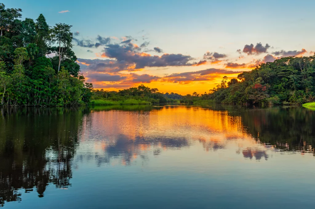 Reflection of a sunset by a lagoon inside the Amazon Rainforest Basin. 
