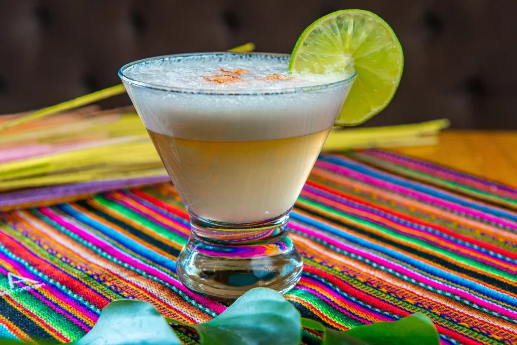 Traditional Peruvian pisco sour cocktail with a slice of lime