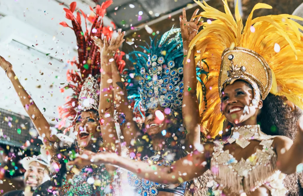 Shot of beautiful samba dancers performing in a carnival with their band.